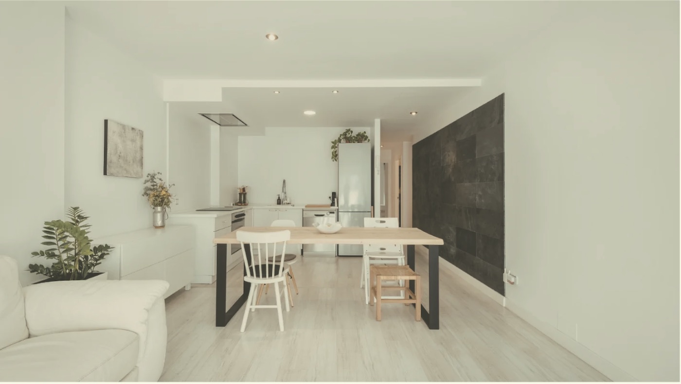 An open-plan dining space and kitchen in soft neutral colors